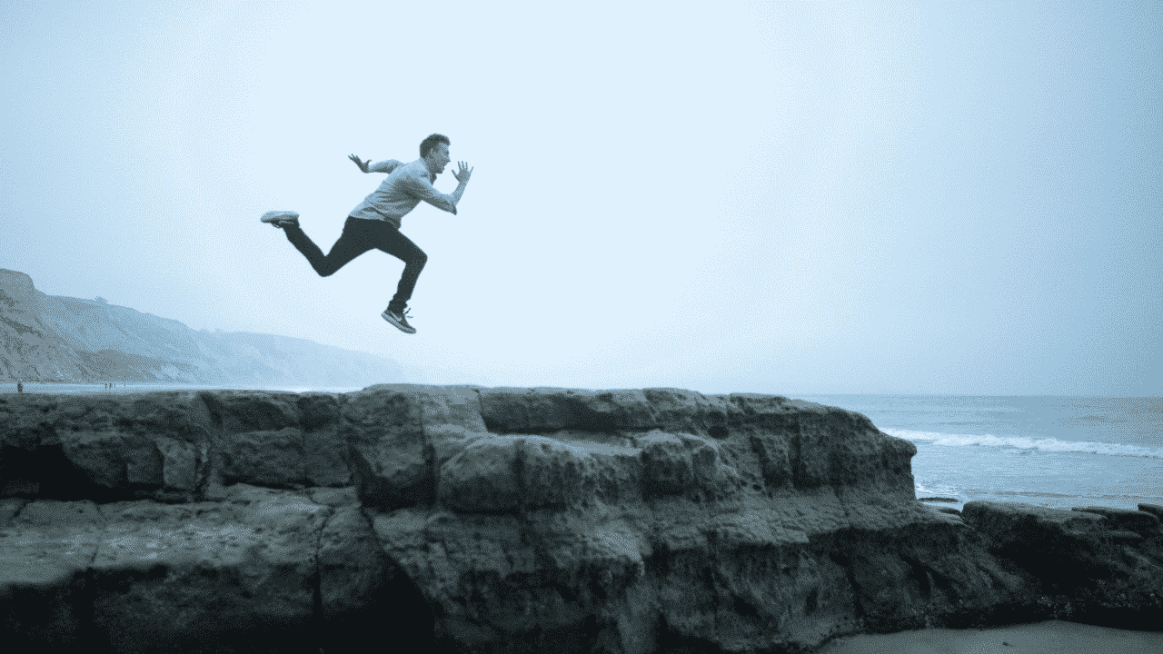man jumping on cliff